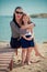 Trendy mother with black hairs and red lips in sun glasses enjoy summer time on a beach with her baby daughter ,Adorable scene of