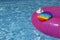 Trendy Pop it Fidget toy and fragment Inflatable ring in swimming pool. Summer day. Splash of water