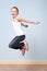 Trendy red-haired girl jumping indoors