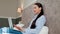 Trendy smiling businesswoman using laptop for video call online in hotel room.