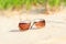 Trendy sunglasses lost on the beach sand. Multicolored outdoors