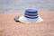 Trendy sunhat and beach thongs on the sand