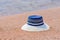 Trendy sunhat lying on beach sand