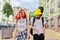 Trendy teenage hipsters boy and girl walking talking on city street