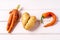 Trendy ugly curved carrot, pepper and potato on white wooden background