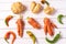 Trendy ugly curved vegetables - potato, carrot and chilli pepper on white wooden background