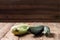 Trendy ugly organic squash and cucumber on natural wooden table on dark blurred background. Copy space