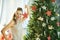 Trendy woman near Christmas tree showing Christmas star