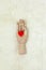Trendy wooden human hand model holds red heart on white fur carpet. Flat lay. February 14th, Happy St. Valentine`s celebration