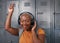 A trendy young black woman listens to music at college in front of lockers