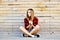 Trendy young girl posing against wooden wall background. Modern