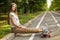 Trendy young happy women sitting in a park put his feet on the longboard and smiling. Skateboarding. lifestyle