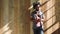 Trendy young man texting on a phone and thinking while standing against a wooden background with copy space. Cool and