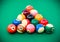 Triangle of colored pool billiard balls on green cloth