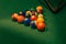 Triangle of numbered billiard balls on green table