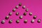 Triangle of quail eggs on a textured pink background