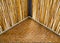 A Triangle red brick wall at the corner of house roof with bamboo.