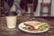 Triangle sandwich and takeaway coffee cup of craft paper on wooden table