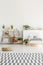Triangle shape shelves units with plants and wooden decorations in a minimalist, natural kid bedroom interior with white walls
