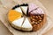 Triangular Cake Pieces Assorted Flavors, Hazelnut, Chocolate, Orange, Blueberry on kraft paper.