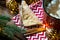 Triangular cookies with powdered sugar and cinnamon on a napkin with a zigzag pattern in the Christmas decor. Red coffee mug with