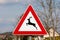 Triangular deer crossing warning road sign which warns that deer often traverse or travel here on this road mounted on metal pole