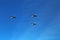 A triangular formation of a group of three russian military fighter bomber jet planes flying high in blue sky during Vicotry Day