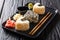 Triangular onigiri with sesame served with ginger, wasabi and soy sauce close-up on a plate. horizontal