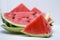 Triangular piece of watermelon and a plate of watermelon slices