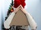 Triangular pizza box in the hands of woman hands. Christmas fast food delivery. New year\'s eve promotion.