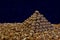 Triangular pyramid of whole walnuts among walnut kernels