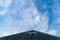 Triangular rooftop pointing toward a beautiful blue, slightly cloudy sky, Block Island, RI