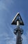 Triangular sign on a high steel pole