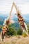 Triangular wooden arch with composition of pampasian grass, dahlia and roses. Decorative floristry