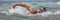 Triathlete man swimming freestyle crawl in ocean panorama banner. Male triathlon swimmer swimming in professional