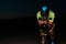 A triathlete rides his bike in the darkness of night, pushing himself to prepare for a marathon. The contrast