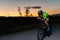 A triathlete rides his bike in the darkness of night, pushing himself to prepare for a marathon. The contrast