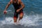 Triathlete swimmer running out of ocean finishing swim race