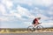 Triathlon cyclist biking on road bike on ironman competition racing against time on nature background landscape. Copy