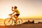 Triathlon race biking cycling sports athlete cyclist man drinking water bottle while riding road bike at sunset after