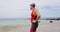 Triathlon swimming - male triathlete swimmer standing on beach after swim