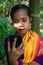 A tribal little girl is listening to music with Bluetooth headphones on her android phone