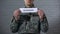 Tribunal word written on sign in hands of male soldier, military court, crime