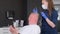 A trichologist conducts a detailed hair diagnosis and examination of an older man.