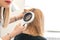 A trichologist examines the condition of the hair on the patients head with a dermatoscope. In a bright cosmetology room