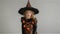 Trick or Treat. Halloween Party. Girl shows the evil sorceress. Child is wearing a black-and-orange dress and hat. From