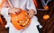 Trick or treat. Little child holding traditional Halloween pumpkin bucket with candies.