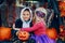 Trick or trunk. Children celebrating Halloween in trunk of car. Boy and girl with red pumpkins celebrating traditional October