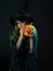 tricky beautiful witch in a pointed hat Holding a pumpkin with a laughing face,