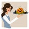 Tricky Halloween Treat. Girl waitress holding a tray with pumpkin, potion and skull. Sweet fun for the day of all evil